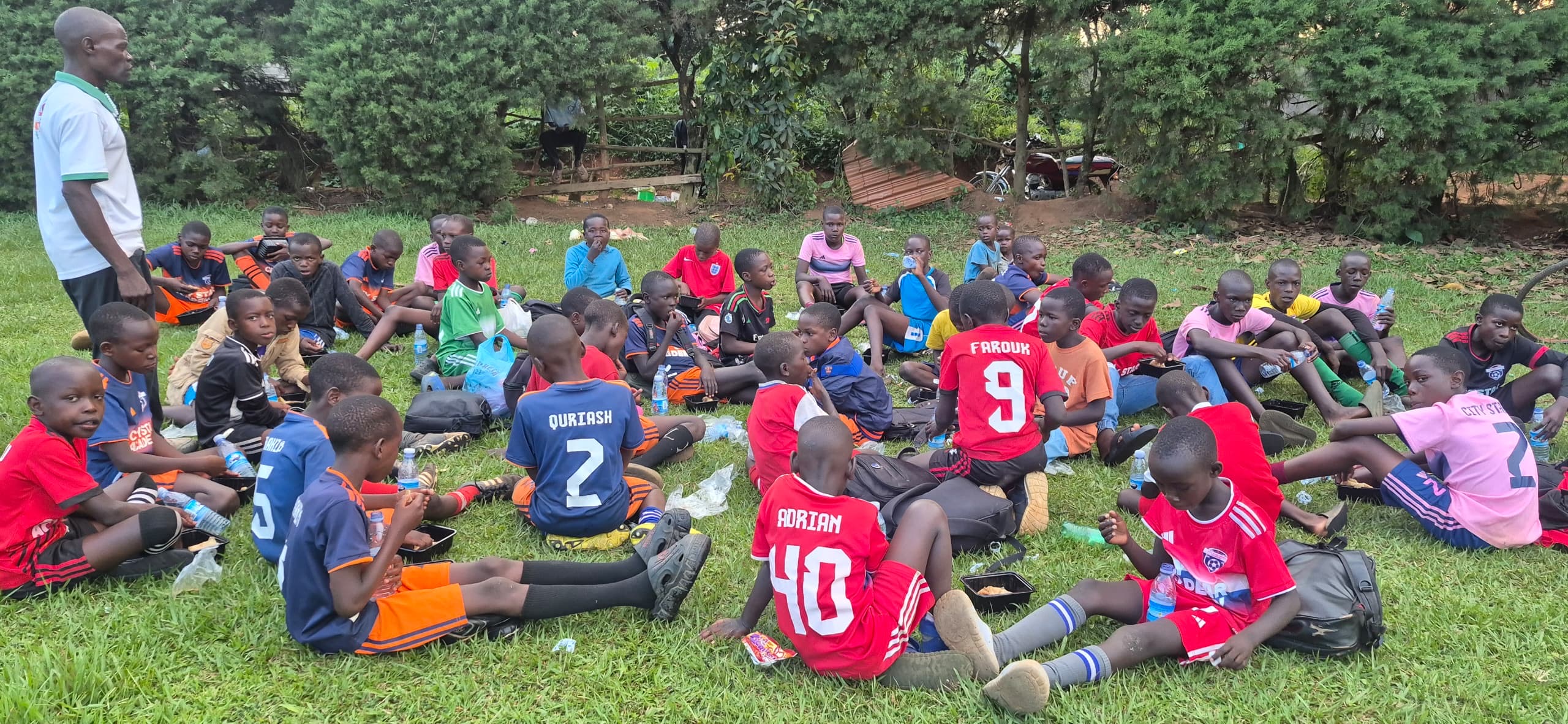Children gathered outdoors during sports ministry in Uganda.